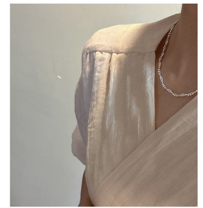 Detailed close-up of a layered S925 sterling silver snake chain necklace on woman neck