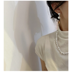 Close-up of minimalist S925 sterling silver double-ball earrings and matching bead chain