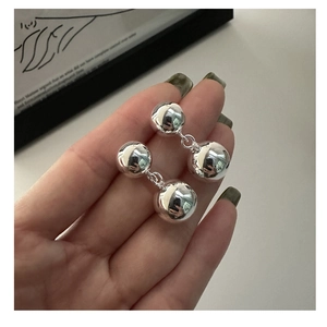 Detailed close-up of S925 sterling silver double ball earrings with a polished mirror finish
