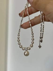 Detailed macro view of S925 silver pearl necklace with a 12mm pendant and heart charm