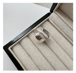 Close-up of S925 sterling silver S-shaped twisted ring inside a luxury beige jewelry box