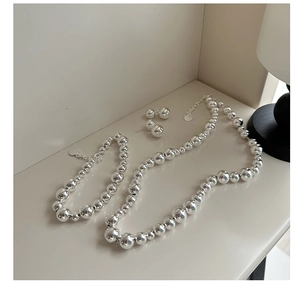 Polished silver bead jewelry set featuring minimalist necklace, bracelet and stud earrings