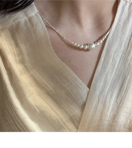 Close-up of elegant S925 sterling silver pearl necklace with gradient size pearls on neck