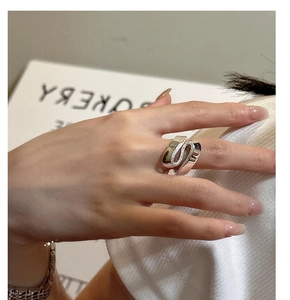 Close-up of S925 sterling silver S-shaped ring with textured detailing on model hand