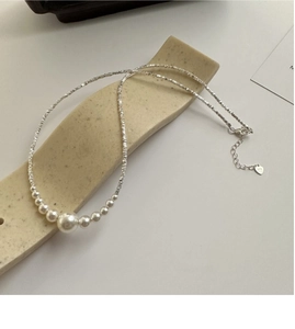 Detail of S925 silver necklace featuring gradient pearls and engraved heart tag