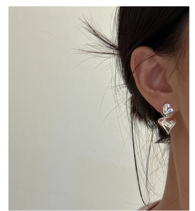 Detail of S925 sterling silver ruffled earrings with organic lava texture on model