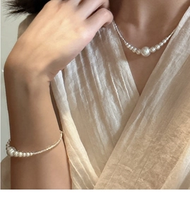 Close-up of elegant S925 silver necklace and bracelet set with gradient white pearls