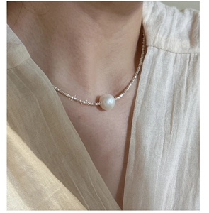 Macro shot of an elegant Edison pearl necklace with silver pieces on a neck