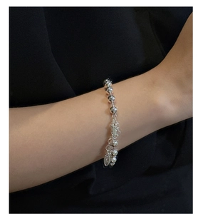 Dettaglio macro di un braccialetto a sfere in argento sterling S925 lucido al polso