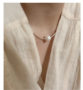 Detail of white Edison pearl on shimmering S925 sterling silver chain with crushed texture
