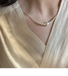 Close-up of elegant gradient pearl necklace with silver chain on model's neck