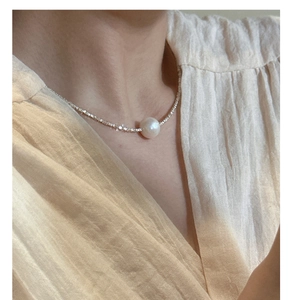 Close-up of S925 silver necklace with a large white pearl pendant on model's neck