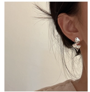 Macro detail of S925 sterling silver geometric ruffled earrings on a female model