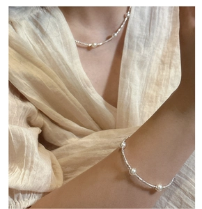 Detail shot of elegant S925 silver necklace and bracelet set with delicate white pearls