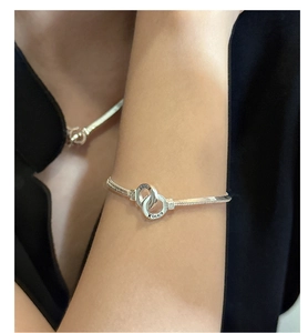 Macro detail of silver S925 snake chain bracelet with double interlocking rings on wrist