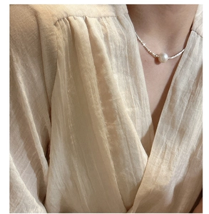 Close-up of S925 silver necklace featuring a large round Edison pearl on a female model