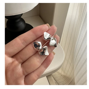 Detailed view of silver S925 earrings with geometric ruffled design and glossy finish