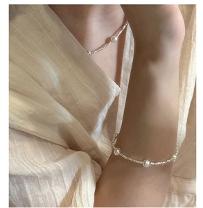 Detail of S925 sterling silver faceted beads and white pearls necklace set on skin