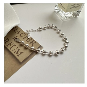 Dettaglio macro del bracciale a sfere in argento sterling S925 lucido con chiusura a moschettone