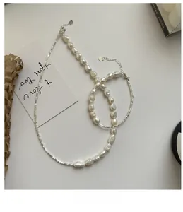 Detailed macro view of baroque pearl necklace with silver beads and heart charm