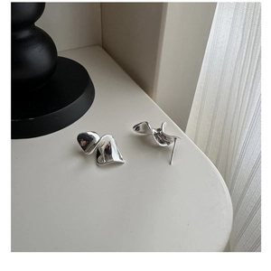 Detailed macro shot of wavy S925 sterling silver earrings with polished metallic finish