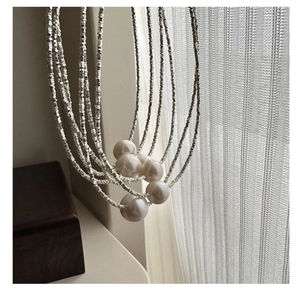 Detail of layered silver beaded necklace with large Edison pearls on draped strands