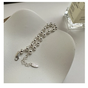 Dettaglio del bracciale a sfere in argento sterling S925 con chiusura a moschettone e catena