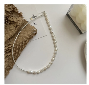 Detailed close-up of a S925 silver beaded necklace with natural baroque pearls and star charm