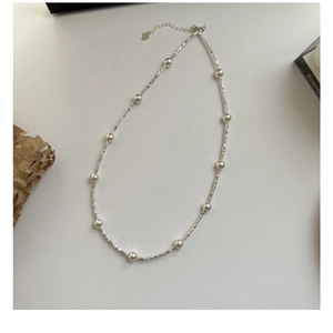 Macro detail of S925 sterling silver beaded necklace with heart charm and extender chain