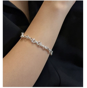Detailed close-up of S925 sterling silver figure-8 knot bracelet on a model's wrist