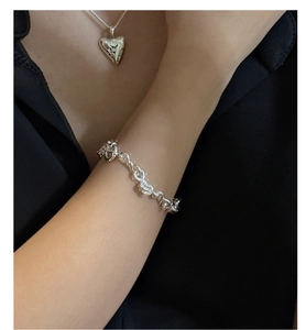 Detailed view of S925 sterling silver infinity knot bracelet on a model wrist