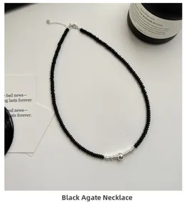 Detail of black onyx bead necklace with silver spiral accent and lobster clasp closure