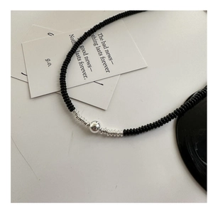 Detail view of 925 silver beaded necklace featuring black agate and spiral metal accents