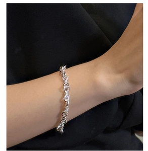 Detailed view of an S925 sterling silver infinity knot bracelet on a female wrist