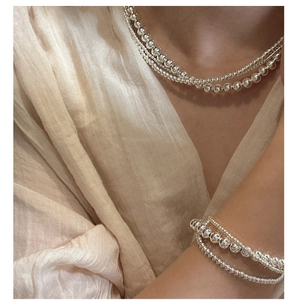 Close-up of S925 sterling silver beaded necklaces layered on a model's neck