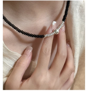 Detail of 925 sterling silver necklace with black agate beads on a model neckline