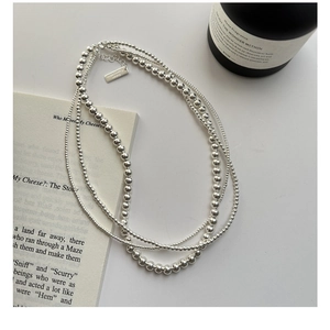 Macro detail of S925 sterling silver triple-layer beaded necklace with adjustable clasp