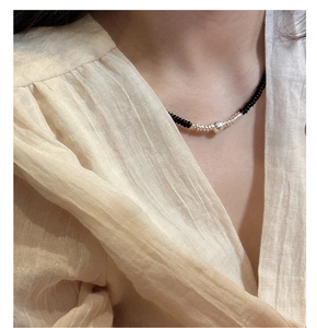 Close-up of 925 silver beaded necklace with black onyx and large silver orb on a model