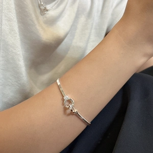 Minimalist S925 sterling silver snake chain bracelet with unique round buckle worn by model