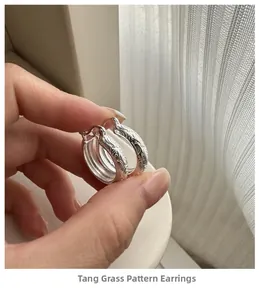 Macro detail of silver hoop earring featuring intricate vintage floral vine engraving
