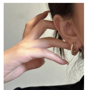 Close-up of minimalist S925 sterling silver hoop earrings on a female model's ear