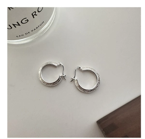 Close-up of S925 sterling silver hoop earrings with intricate vintage floral engraving