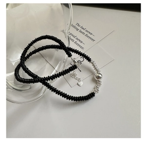 Detail of 925 silver necklace with black agate beads and polished silver ball pendant