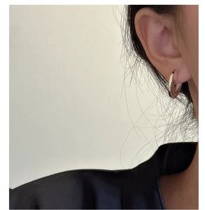 Close-up of minimalist gold circular hoop earrings worn for a sleek geometric look