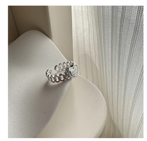 Macro shot of silver heart ring featuring ONESELF LOVE engraving and chain link band