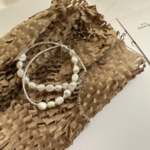S925 sterling silver necklace with baroque pearls and small square beads on brown paper