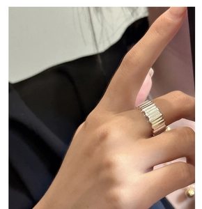 Close-up of wide S925 sterling silver ring with vertical striped texture on a finger