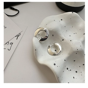 Detail of chunky S925 sterling silver hoop earrings with organic liquid metal texture