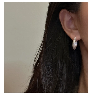 Close-up of vintage S925 silver hoop earrings with intricate baroque floral engraving
