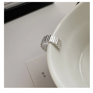 Macro shot of S925 sterling silver ring featuring vertical stripes on a white ceramic edge